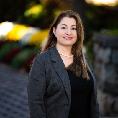 Photo of Emilia Klein outdoors with greenery behind.
