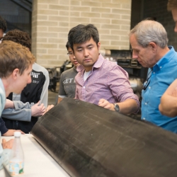 JHO team examines one of the aircraft’s carbon fiber wings, constructed by the student team in AeroAstro’s Building 33 Neumann Hangar. Photo: MIT News