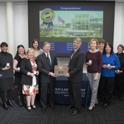 Holding the 12th consecutive Superior Security rating plaque are Shawn Daley, head of Security Services, left, and Eric Evans, Laboratory director. Joining them are representatives from the groups and divisions audited for the 2017 security review.