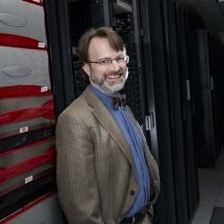 Jeremy Kepner poses with LLSC server stacks.