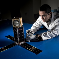 Mike DiLiberto leanes next to the MicroMAS-2A cubesat.