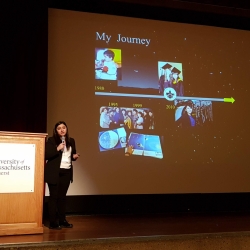 Yari Golden-Castano stands on stage in front of a slide titled "My Journey" as she gives a plenary talk.