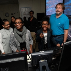 Three students direct virtual planes down the runway with the help of Brad Crowe. Photo: Nicole Fandel