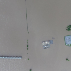 aerial photo of a flooded area with building roofs visible.