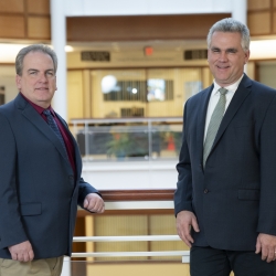 Two staff members pose for a photo in the Laboratory atrium. 