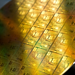 A photo of gold-colored integrated circuit wafer.