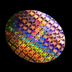 A photo of a multicolored wafer containing integrated circuits. 