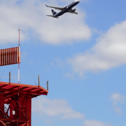 an airplane flies behind a spinning radar.