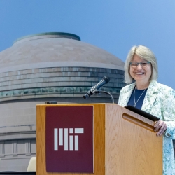 Sally Kornbluth pictured standing behind a podium that says MIT on it 