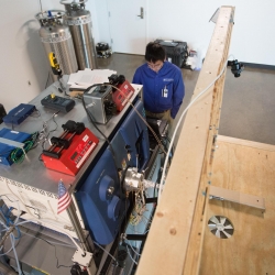Researchers conducted vapor measurements in situ with canines. The canines walked up onto the wooden platform to smell a training object while the mass spectrometer validated the presence of trace explosive vapors on the object.