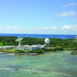 A photograph of an island with four radars.