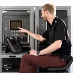 An individual sitting in front of a test terminal presses a button.