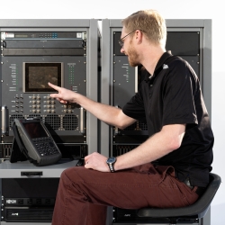 An individual sitting in front of a test terminal presses a button.