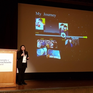 Yari Golden-Castano stands on stage in front of a slide titled "My Journey" as she gives a plenary talk.