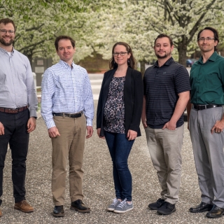 Five staff members pose for a group photo.