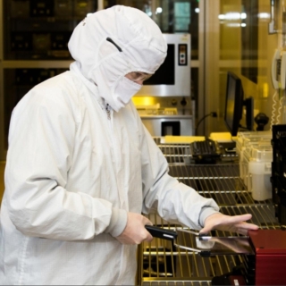 a technician loads a reticle (a kind of optical blueprint) into the 193-nm lithography tool used in the sensor production process.