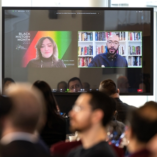 A screen shows Clint Smith III, a nationally recognized poet and educator, and moderator Bonnie Walker, the Laboratory's principal diversity and inclusion officer.