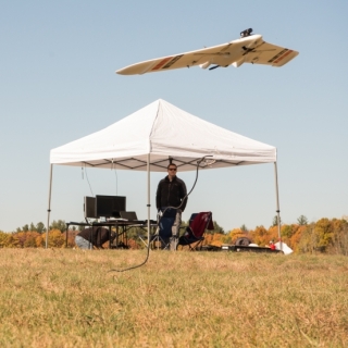 a person flying a small UAV in a field