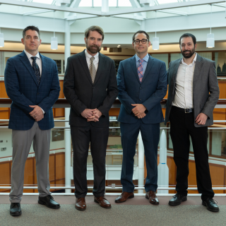 Four leaders representing Air University and Lincoln Laboratory stand for a group photo.