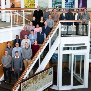 A group of 24 people representing Lincoln Laboratory and students and staff of the Air Command and Staff college pose for a group photo. 