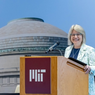 Sally Kornbluth pictured standing behind a podium that says MIT on it 