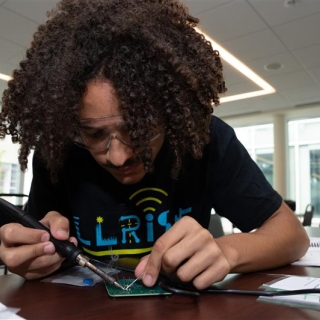 A student in the LLRISE program works to solders part of a radar.