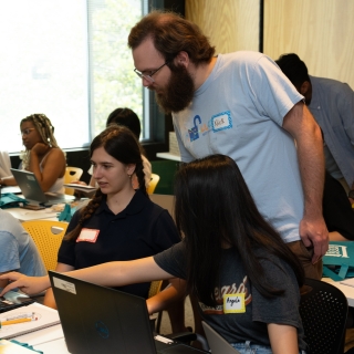A Lincoln Laboratory staff member assists high school students during the 2024 LLCipher event