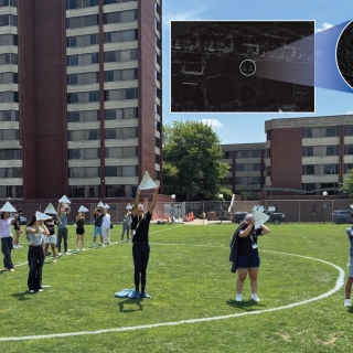 Students hold radar reflectors as they stand on a soccer field. An inset image shows two Ls as seen from space.
