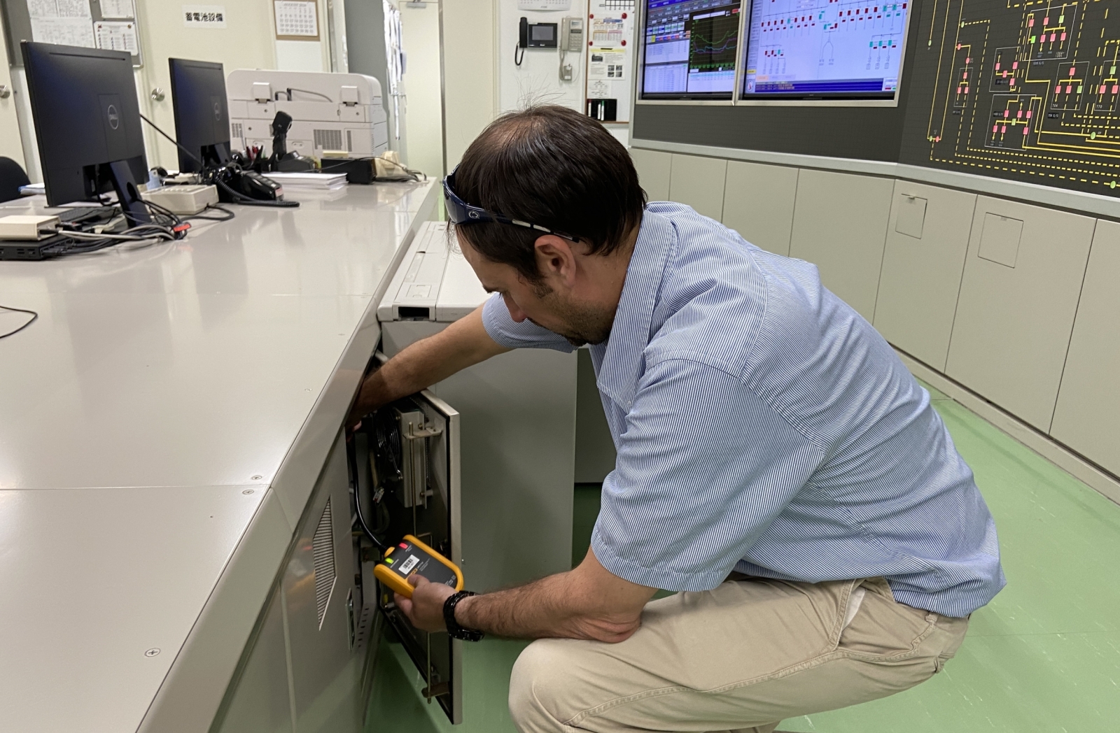 A researcher checks on equipment in a cabinet. 