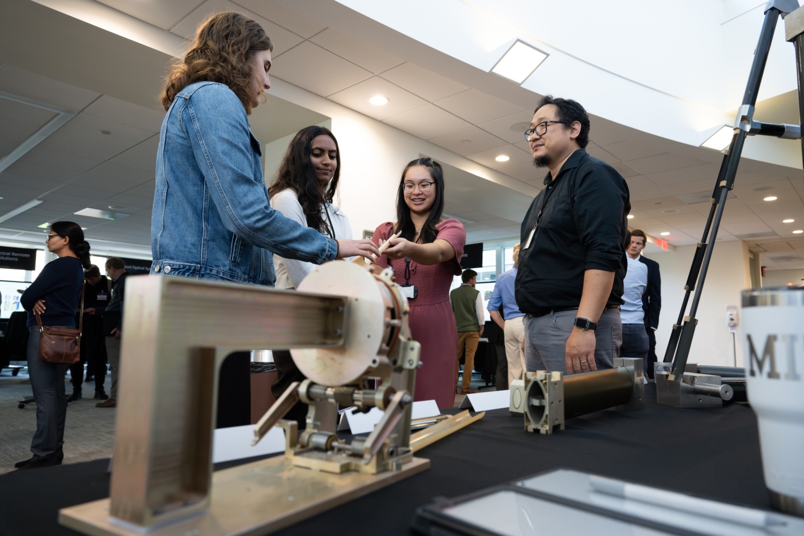 Four attendees chat in the backdrop of two technologies shown in the foreground. 