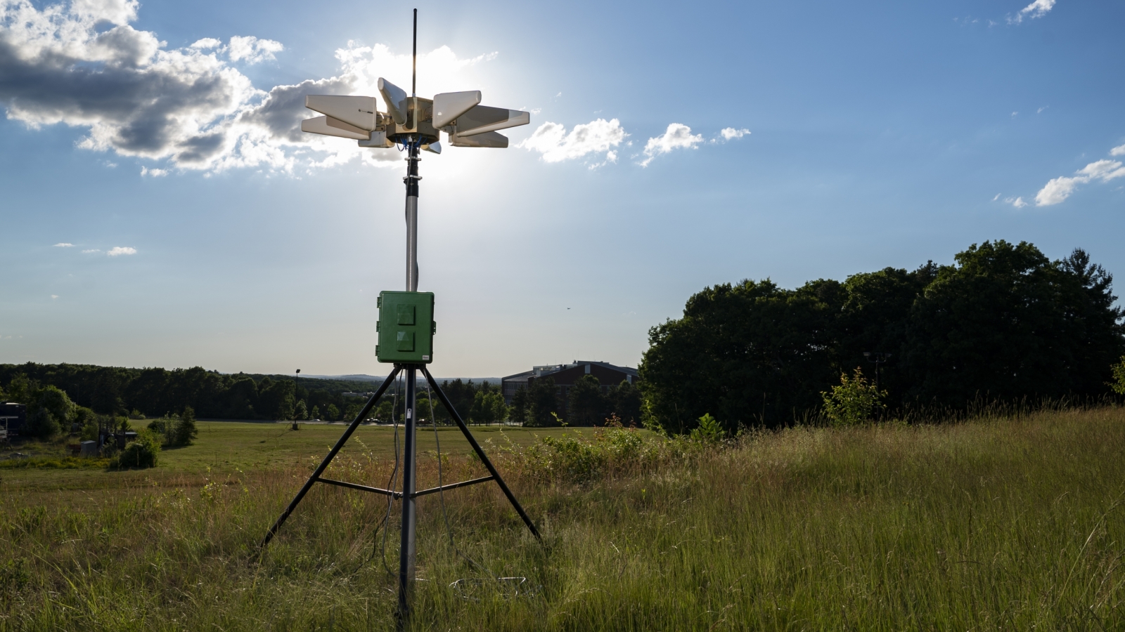 a sensor/instrument on a tripod, set up in a field.