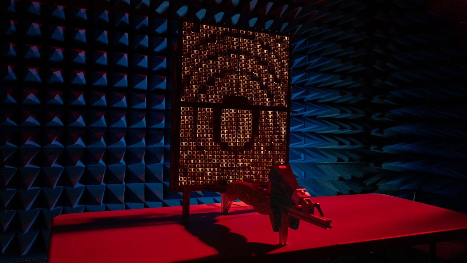 A prototype reflectarray faces a feed horn in an anechoic chamber. 