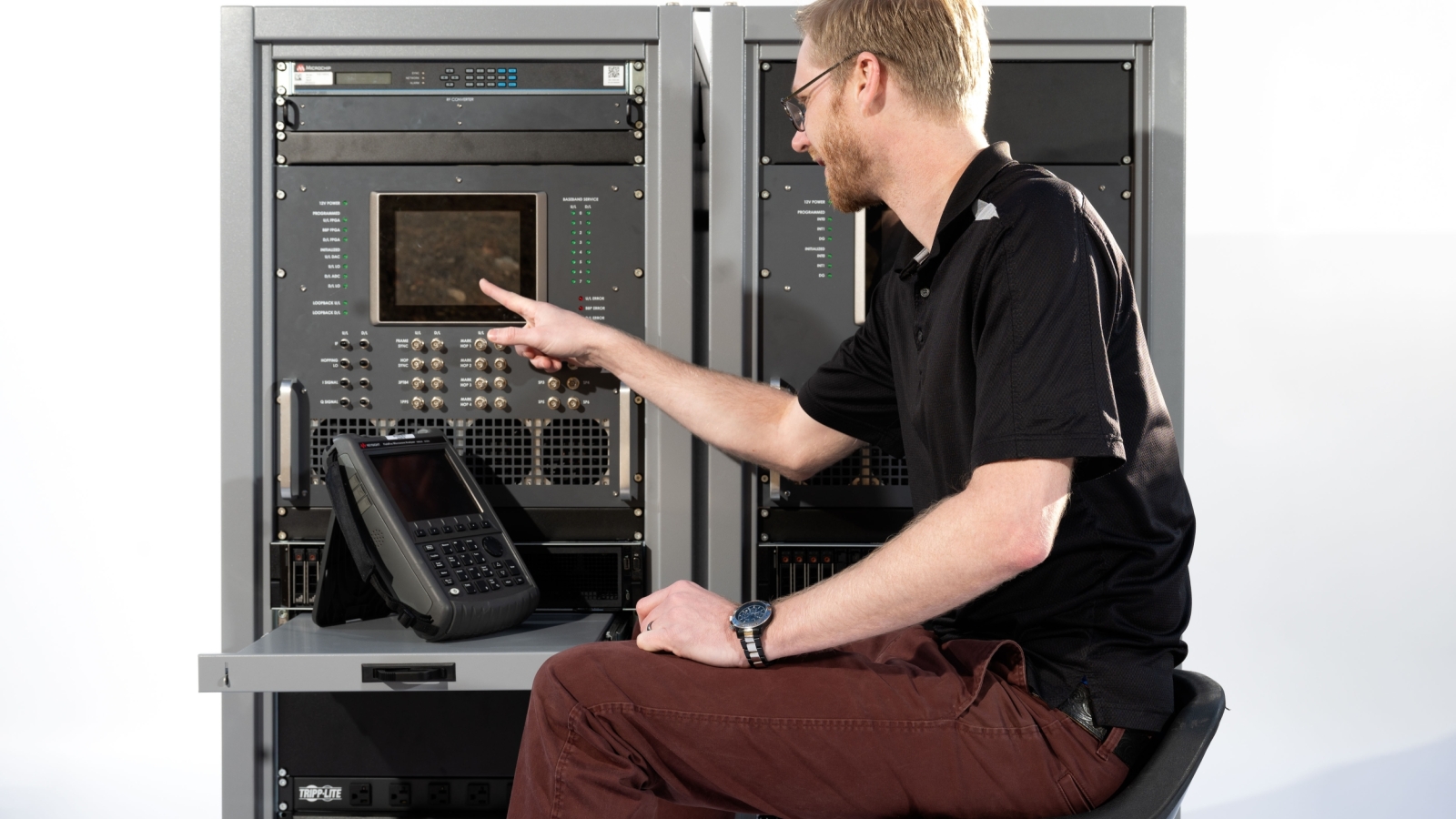An individual sitting in front of a test terminal presses a button.