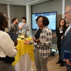 three people talking around a high top table at a poster session
