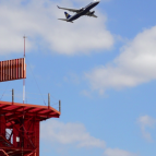 an airplane flies behind a spinning radar. 