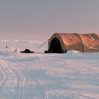 A large tent and supplies sit atop ice in the Arctic. 