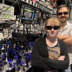Lincoln Laboratory researchers Lucy Gray Shamel and Will Setzer wear protective glasses while standing next to the optics systems they used for the research. 