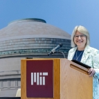 Sally Kornbluth pictured standing behind a podium that says MIT on it 