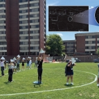 Students hold radar reflectors as they stand on a soccer field. An inset image shows two Ls as seen from space.